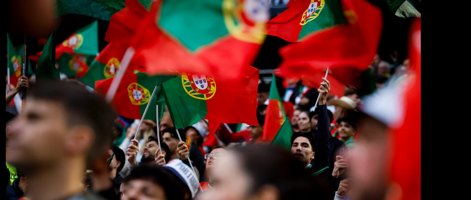 Adeptos a apoiar Portugal com bandeiras na bancada